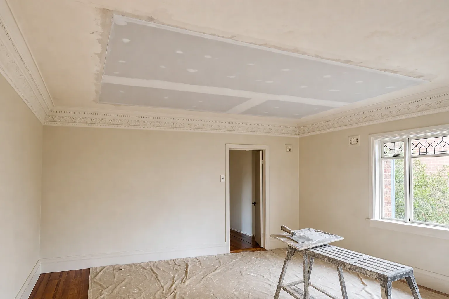 Character lounge room with ornate plaster cornice and a freshly fixed plasterboard ceiling section, set and sanded ready for paint