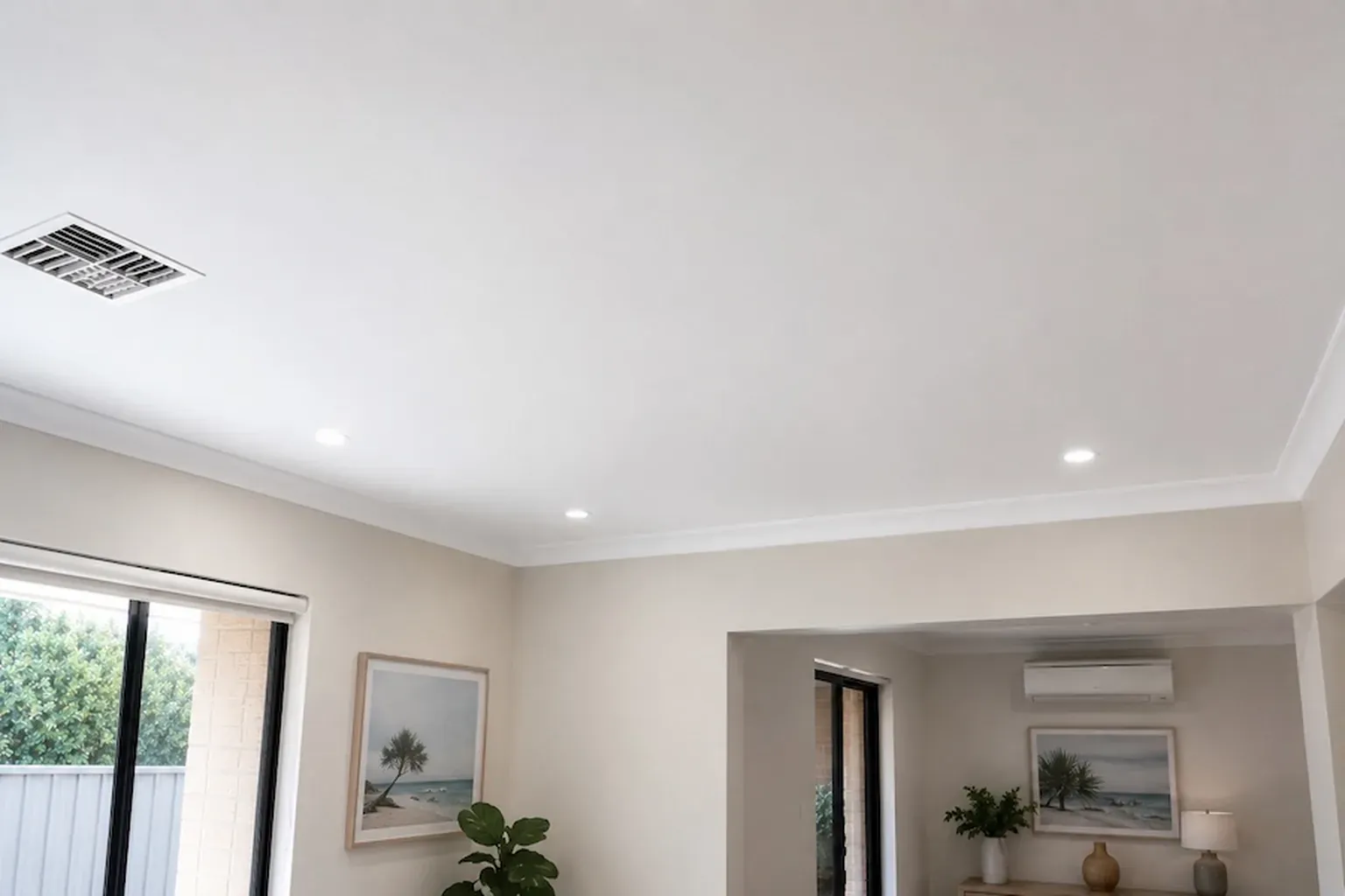 Finished flat ceiling with cornice, downlights and an air-conditioning vent in a living room