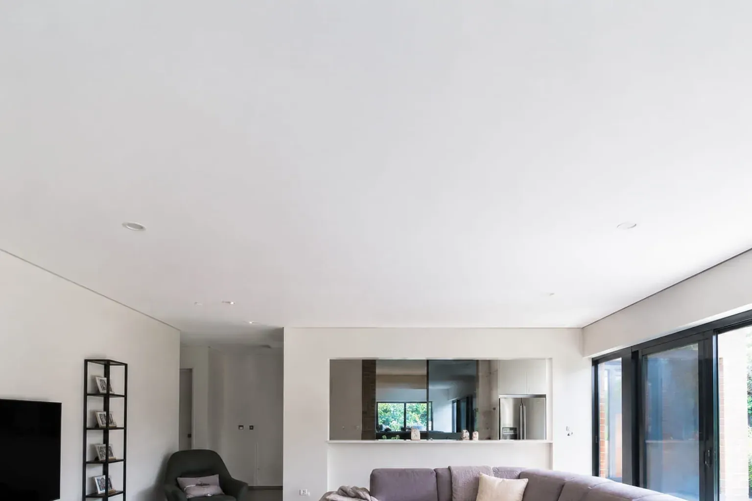 Finished white plasterboard ceiling with a bulkhead over an open-plan living room