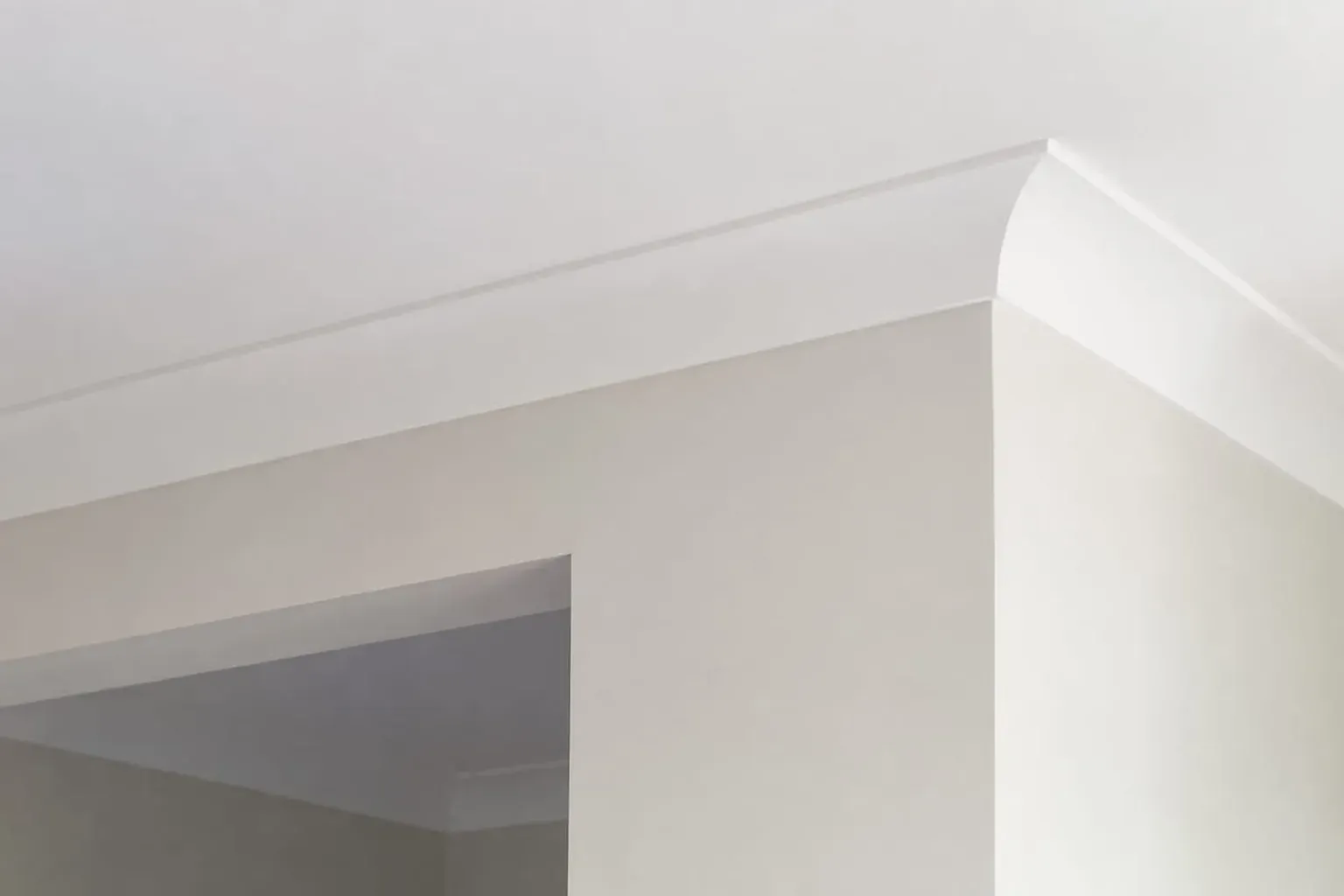 Plain cove cornice running along a wall and across a bulkhead in a newer home