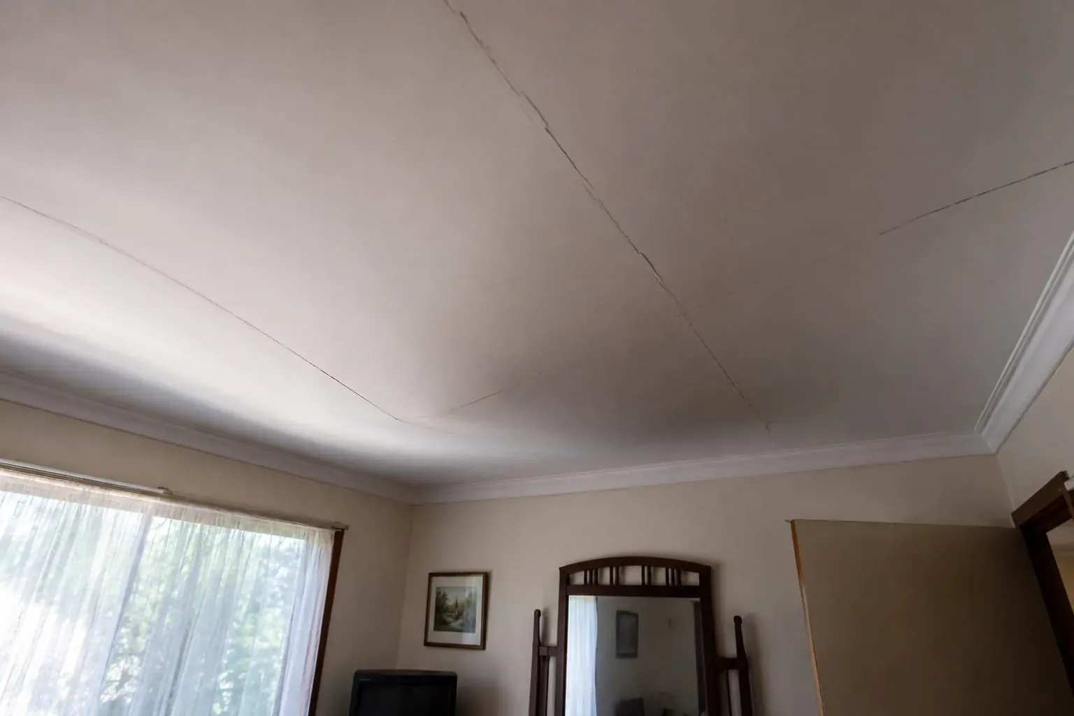 Plasterglass ceiling in an older Perth lounge room sagging across the span with cracks opening along the sheet joins